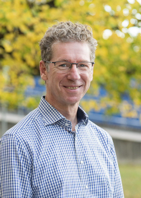 Portrait des Wissenschaftlers vor einem Baum im Herbst