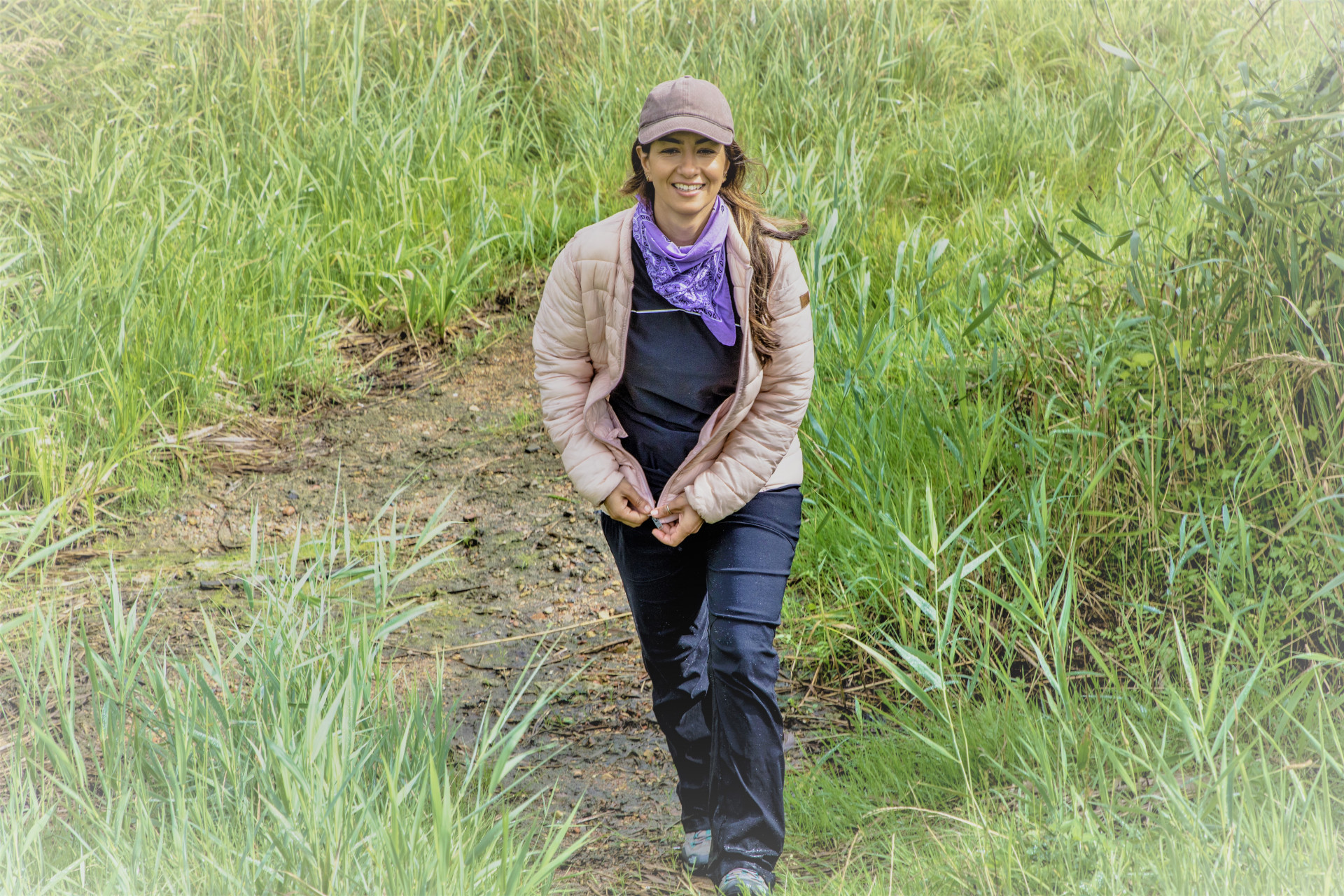 Eine Frau läuft durch eine grün-braune Moorlandschaft