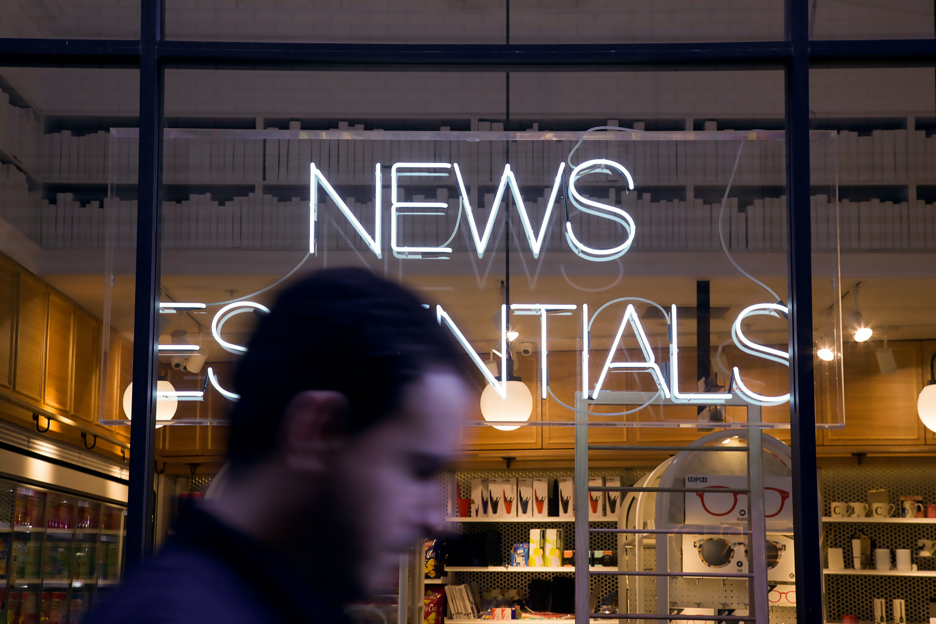 Verschwommen der Kopf eines Mannes vor einem Schaufenster, Schriftzug News Essentials