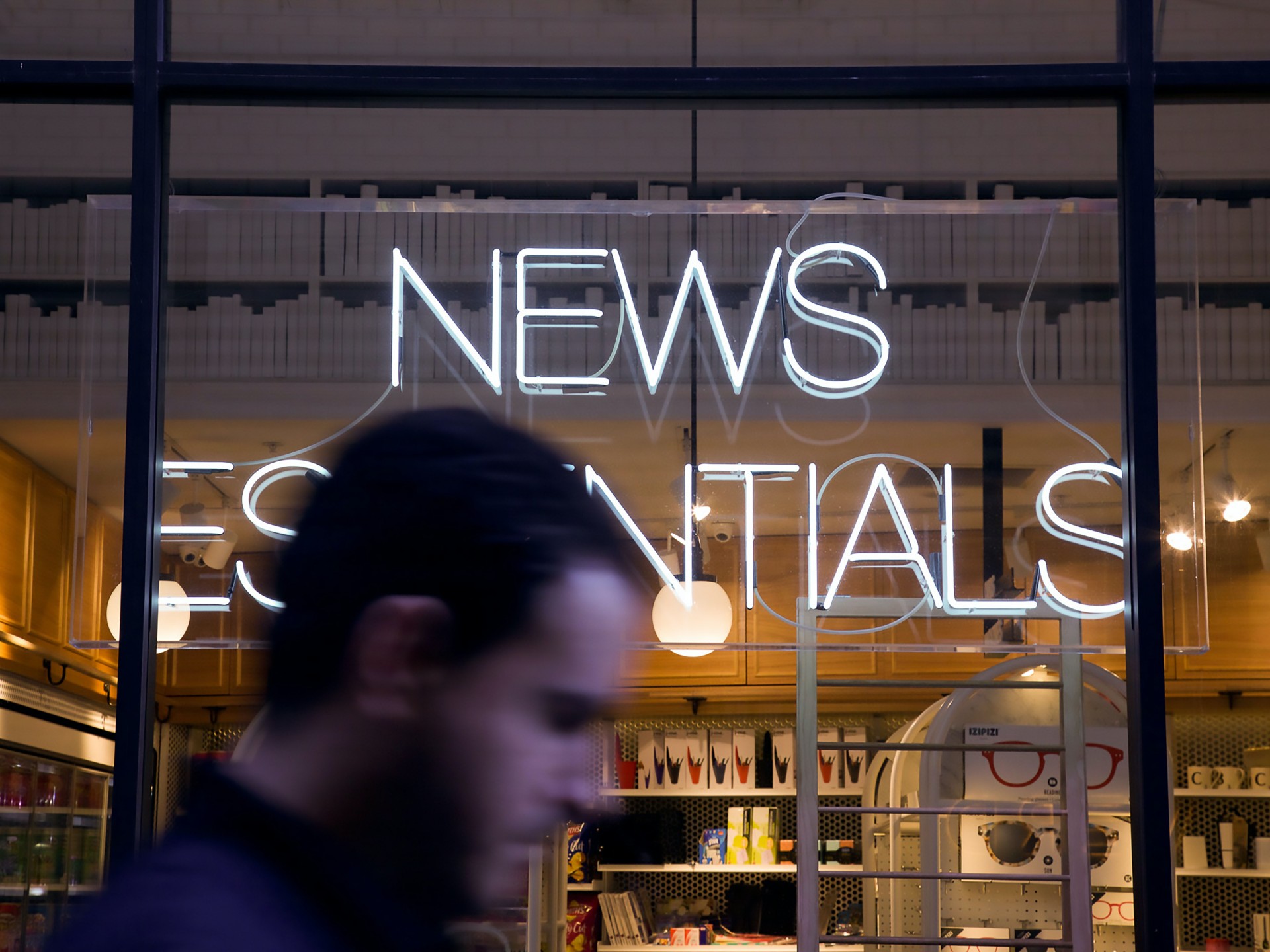 Verschwommen der Kopf eines Mannes vor einem Schaufenster, Schriftzug News Essentials