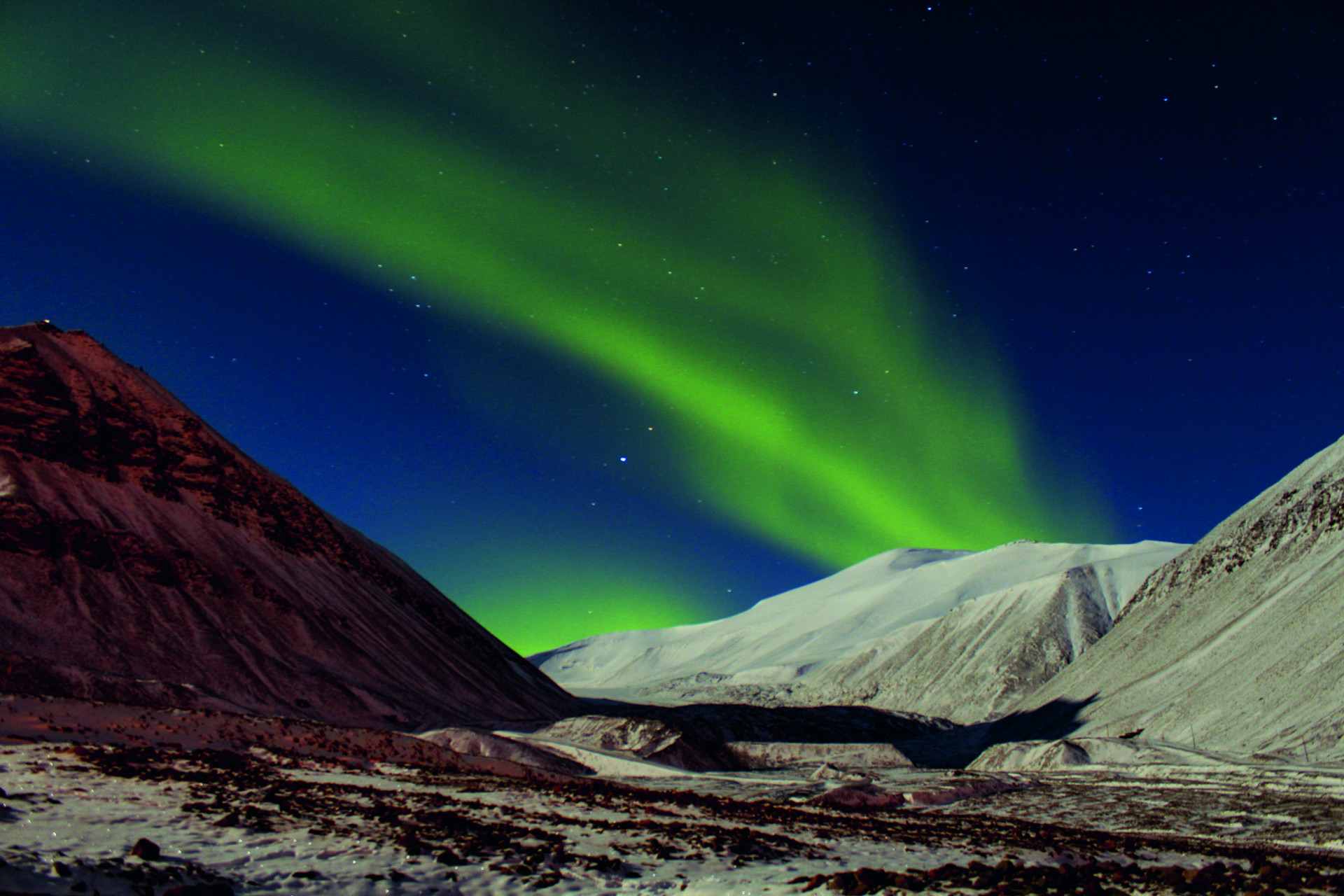 Polarlichter über weißen Hügeln