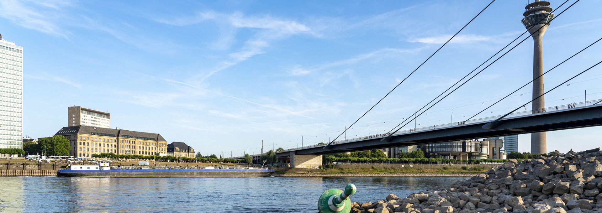 Rhein bei Düsseldorf, extremes Niedrigwasser unter Brücke, ein Frachtschiff passiert den Fluss. (2022)