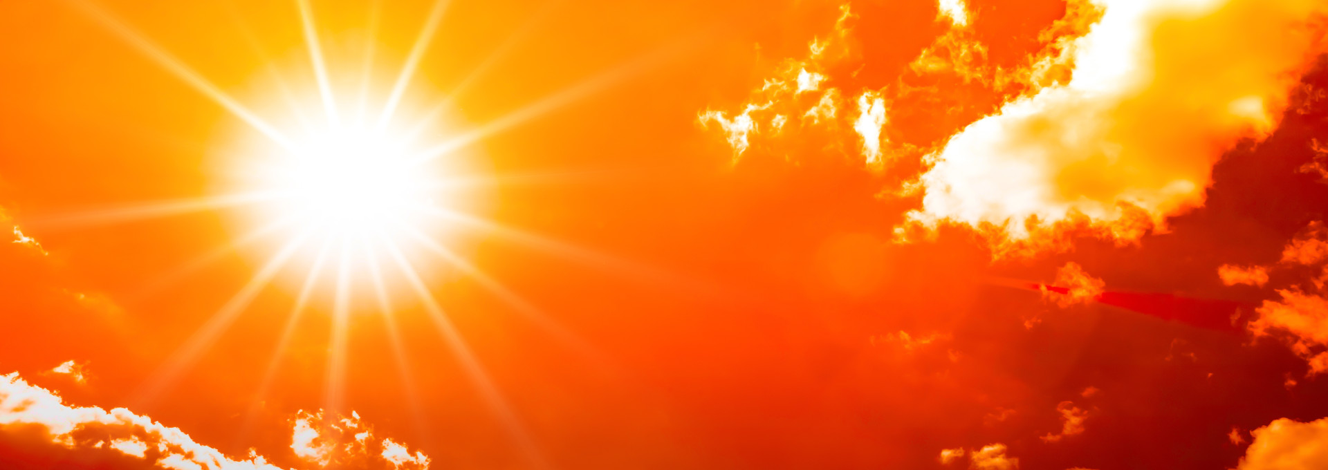 orange sky with clouds and bright sun