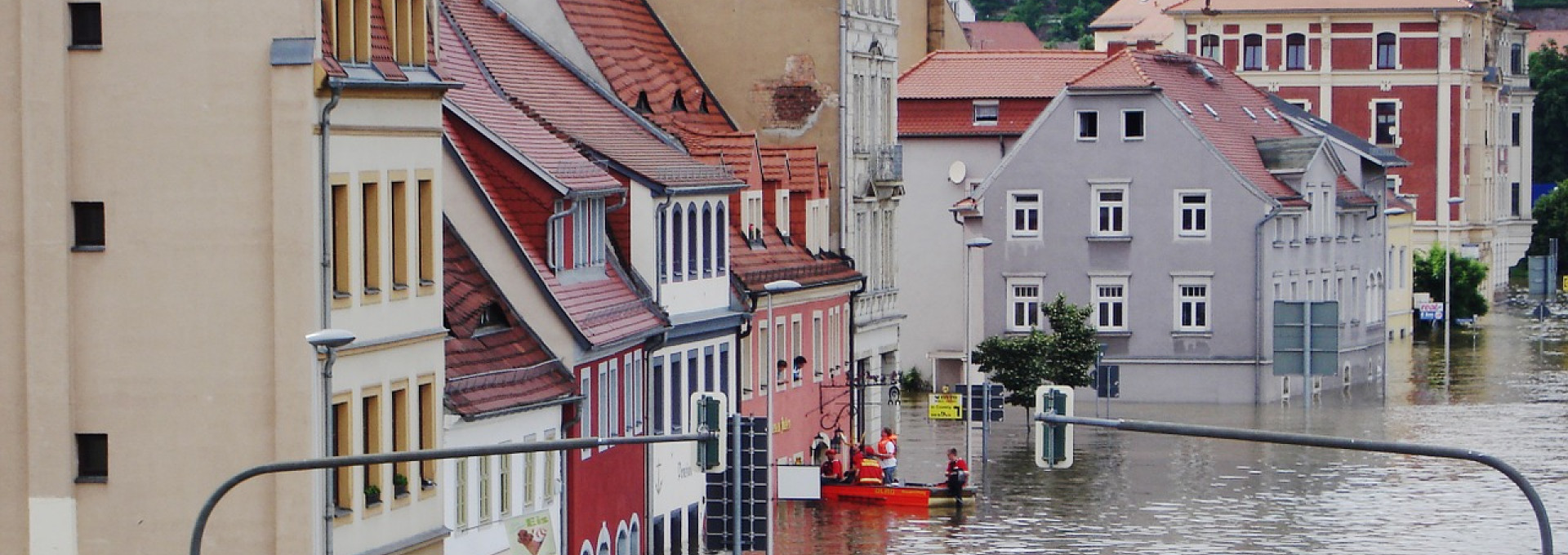 Completely flooded town center, people in rubber boat