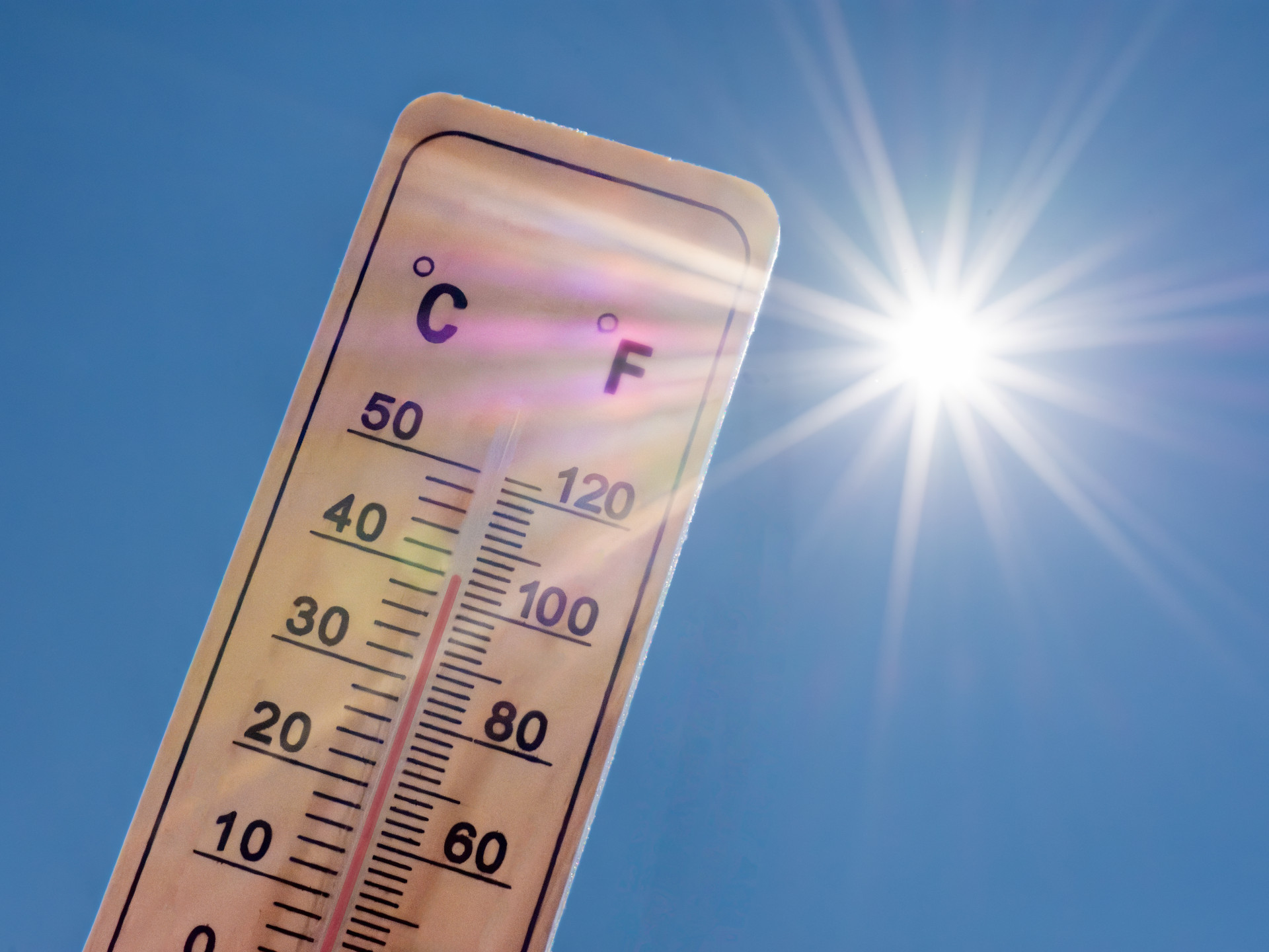 Thermometer zeigt 40 Grad Celsius vor blauem Himmel