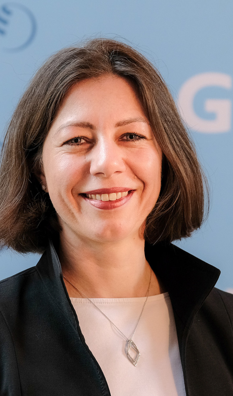Porträtfoto von Prof. Katja Matthes, Direktorin des GEOMAR, vor blauem Hintergrund mit dem Logo des Helmholtz-Zentrum für Ozeanforschung