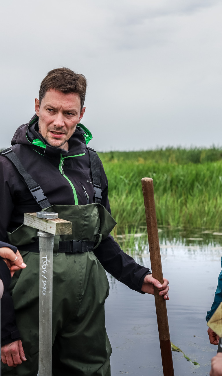 Four scientists in a peatland, dressed in outdoor clothing.