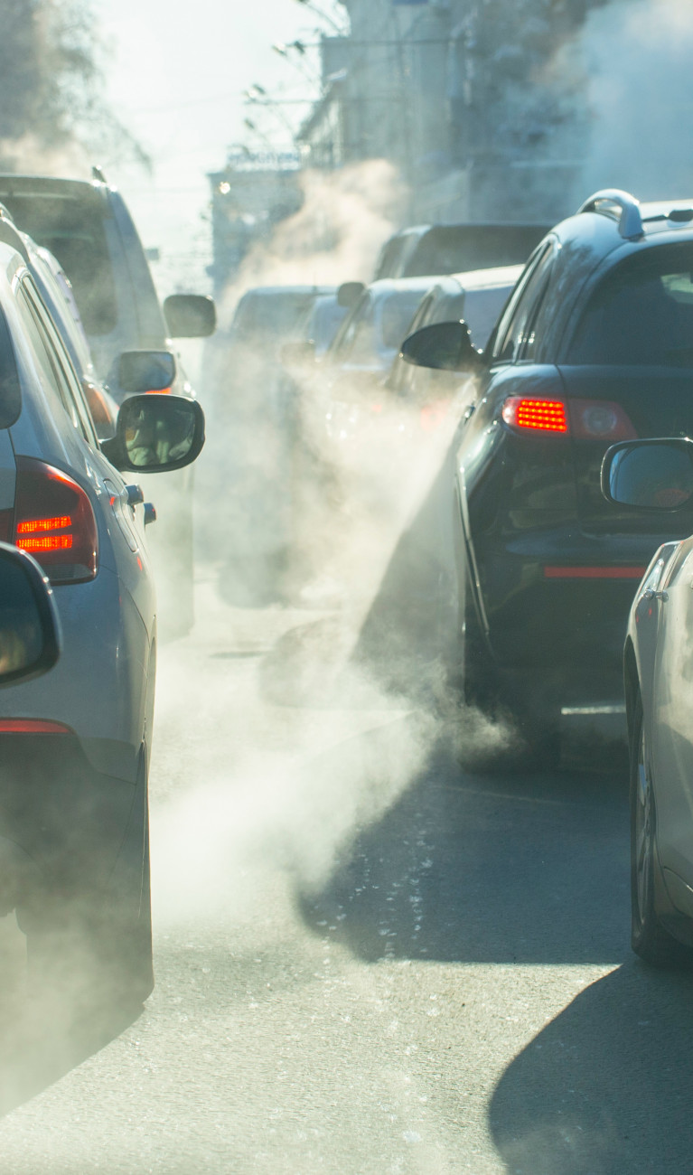 Verschmutzung durch die Abgase von Autos in der Stadt im Winter. Abgase von Autos an einem kalten Wintertag.