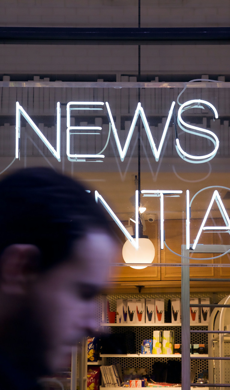 Verschwommen der Kopf eines Mannes vor einem Schaufenster, Schriftzug News Essentials