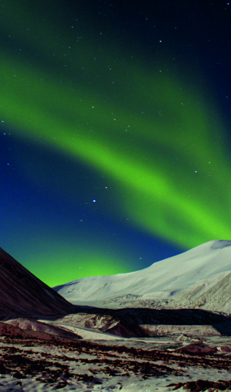 Polarlichter über weißen Hügeln