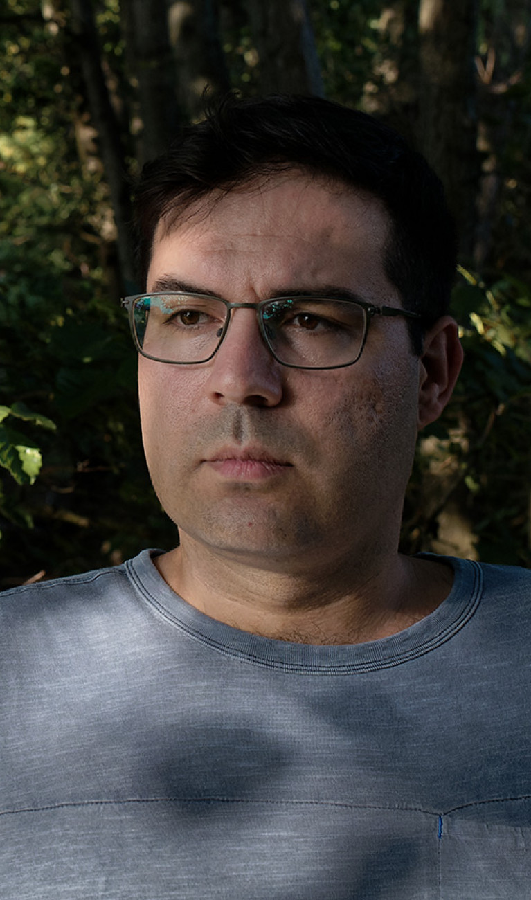 Ugur Öztürk in the shadow of trees.