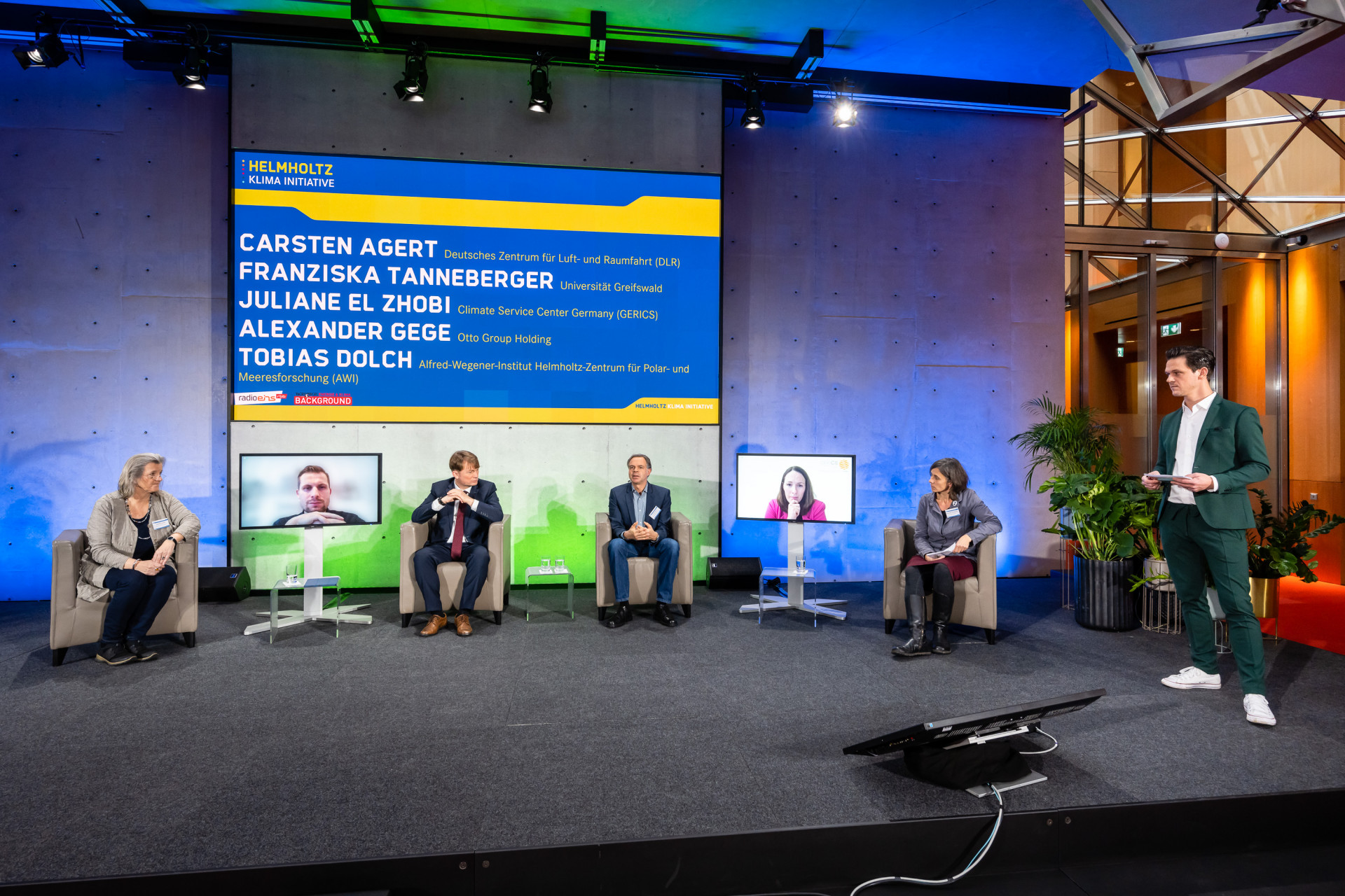 Podiumsteilnehmer:innen sitzen auf der Bühne