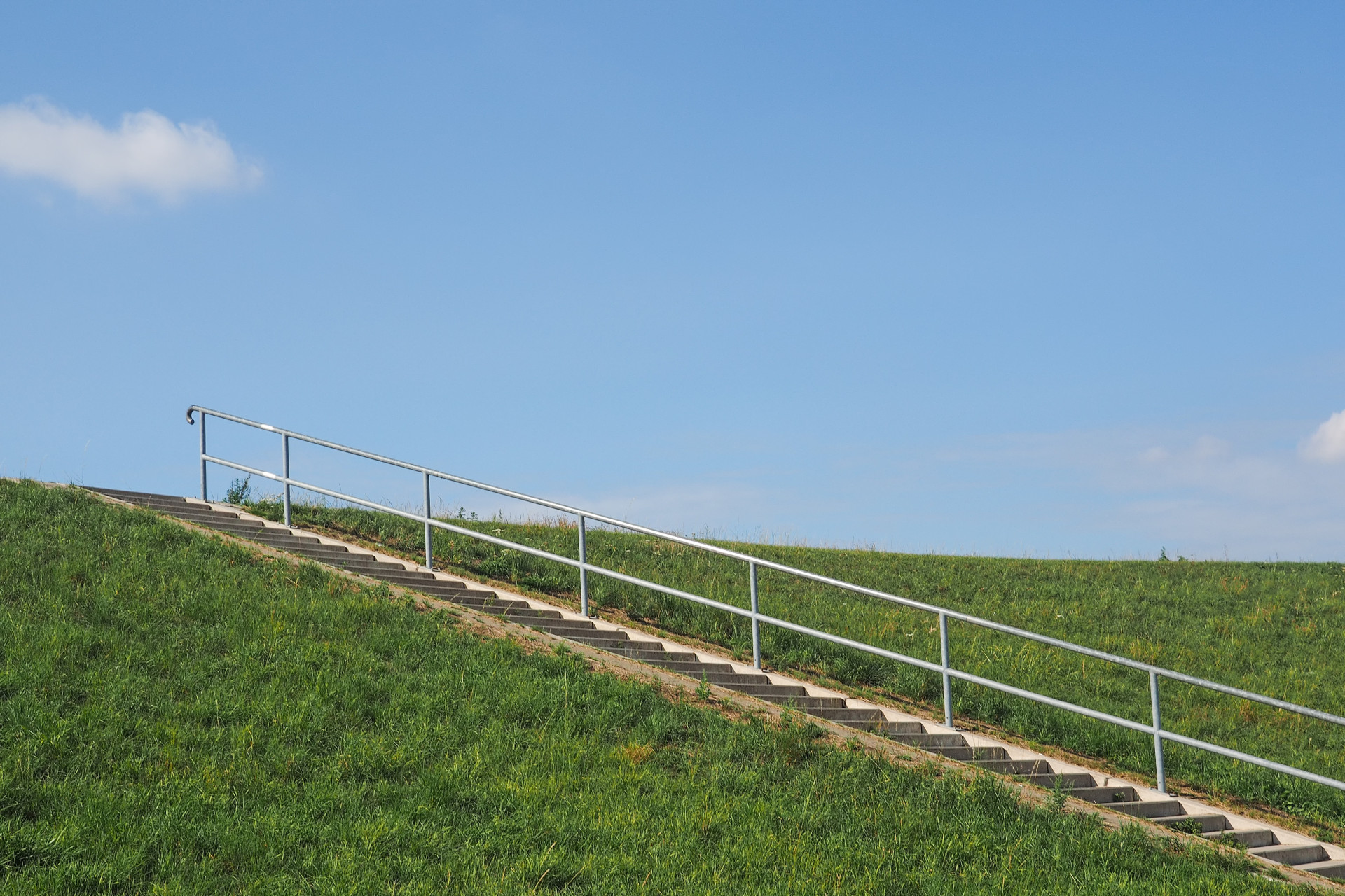 Eine Treppe führt auf einen Deich hinauf