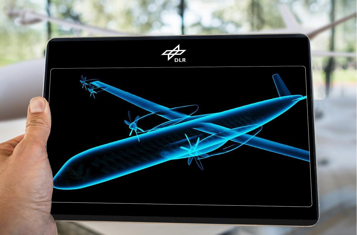 Eine futuristische Silhouette eines Flugzeugs auf einem Tablet, den jemand in der Hand hält.