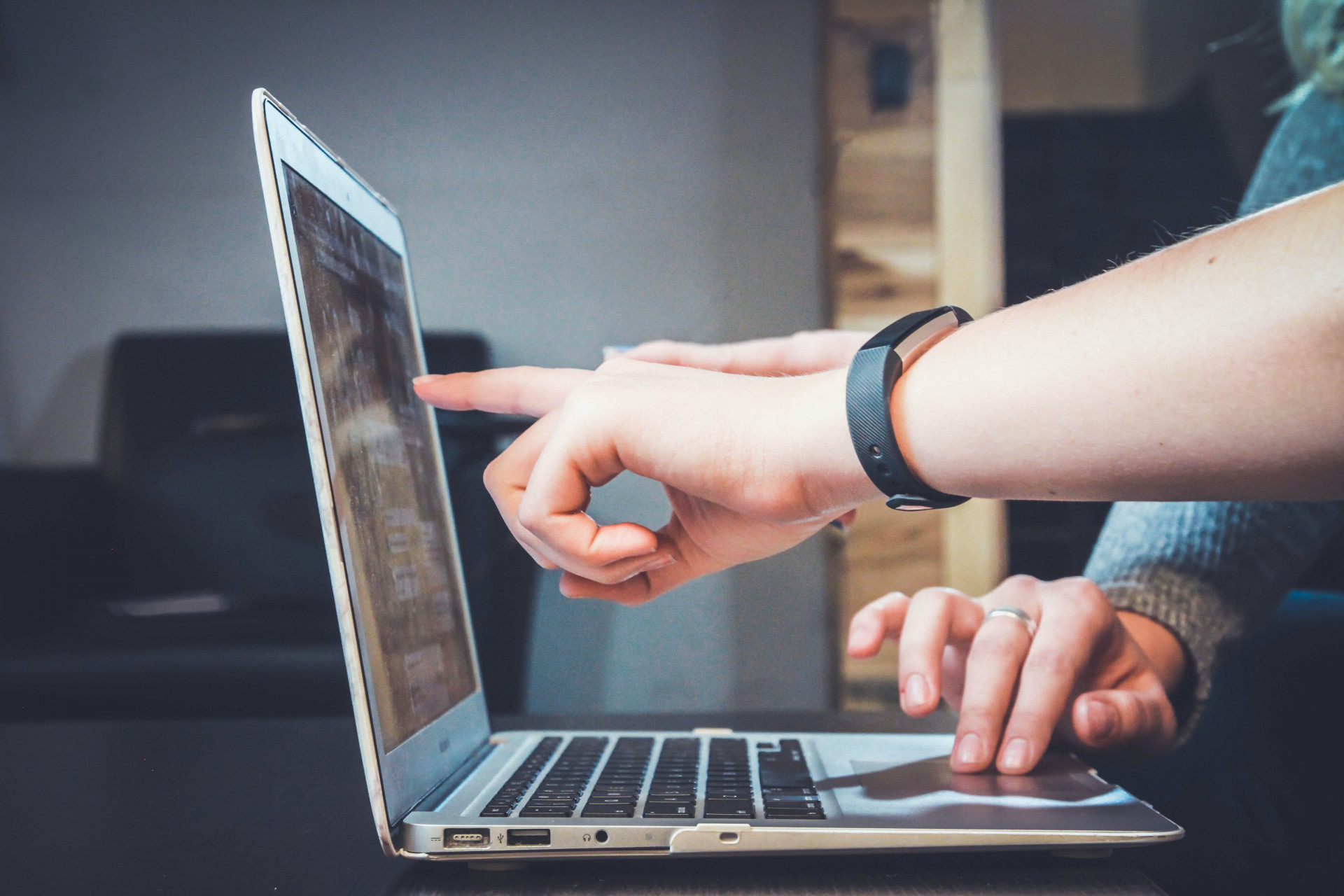 Personen zeigen mit dem Finger auf Laptop-Bildschirm