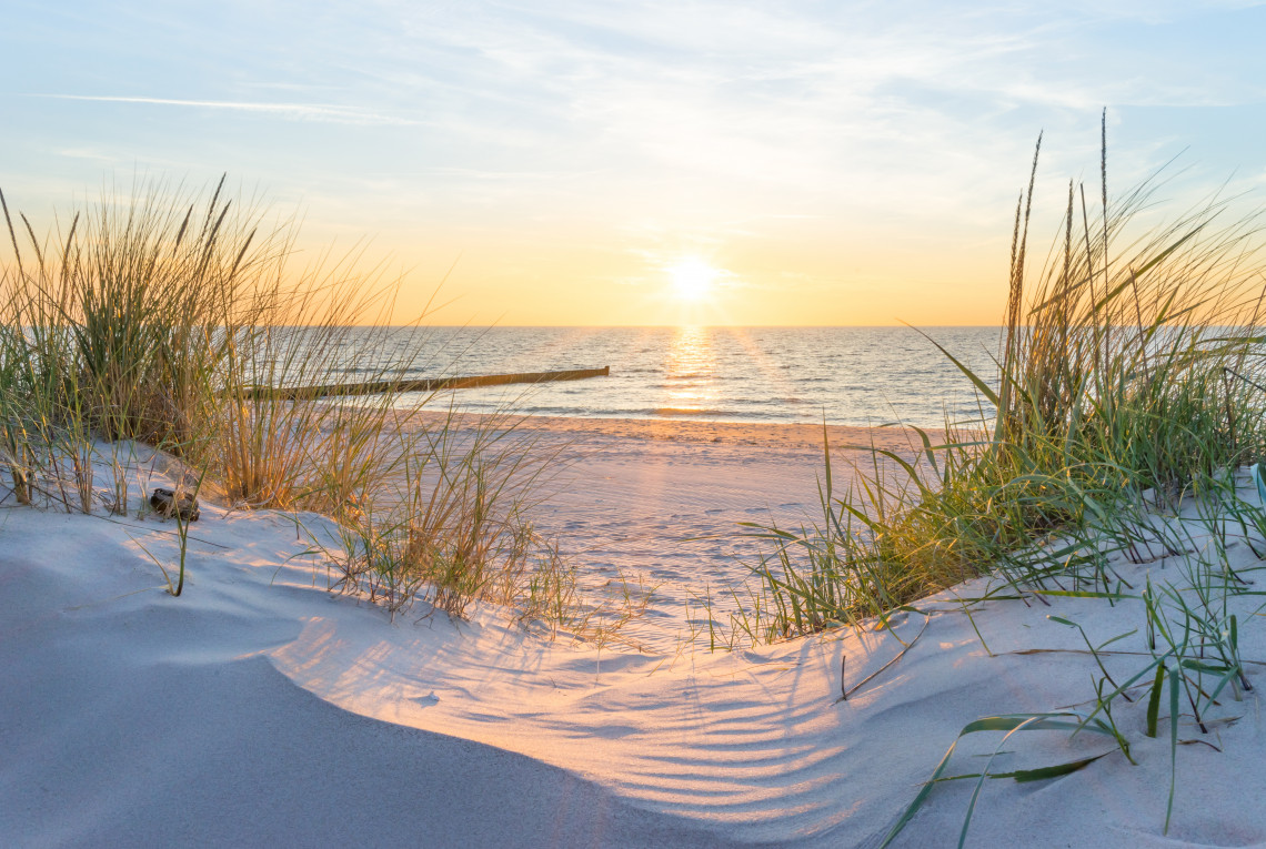 Sandstrand mit Dünen und Sonnenuntergang