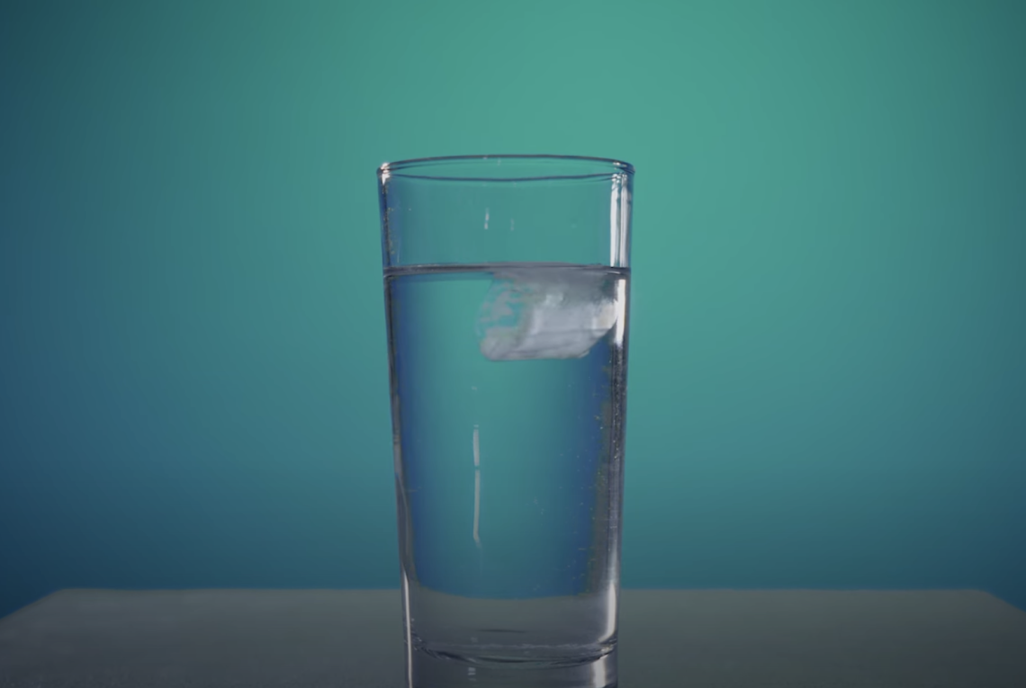 Wasserglas mit schmelzendem Eis 