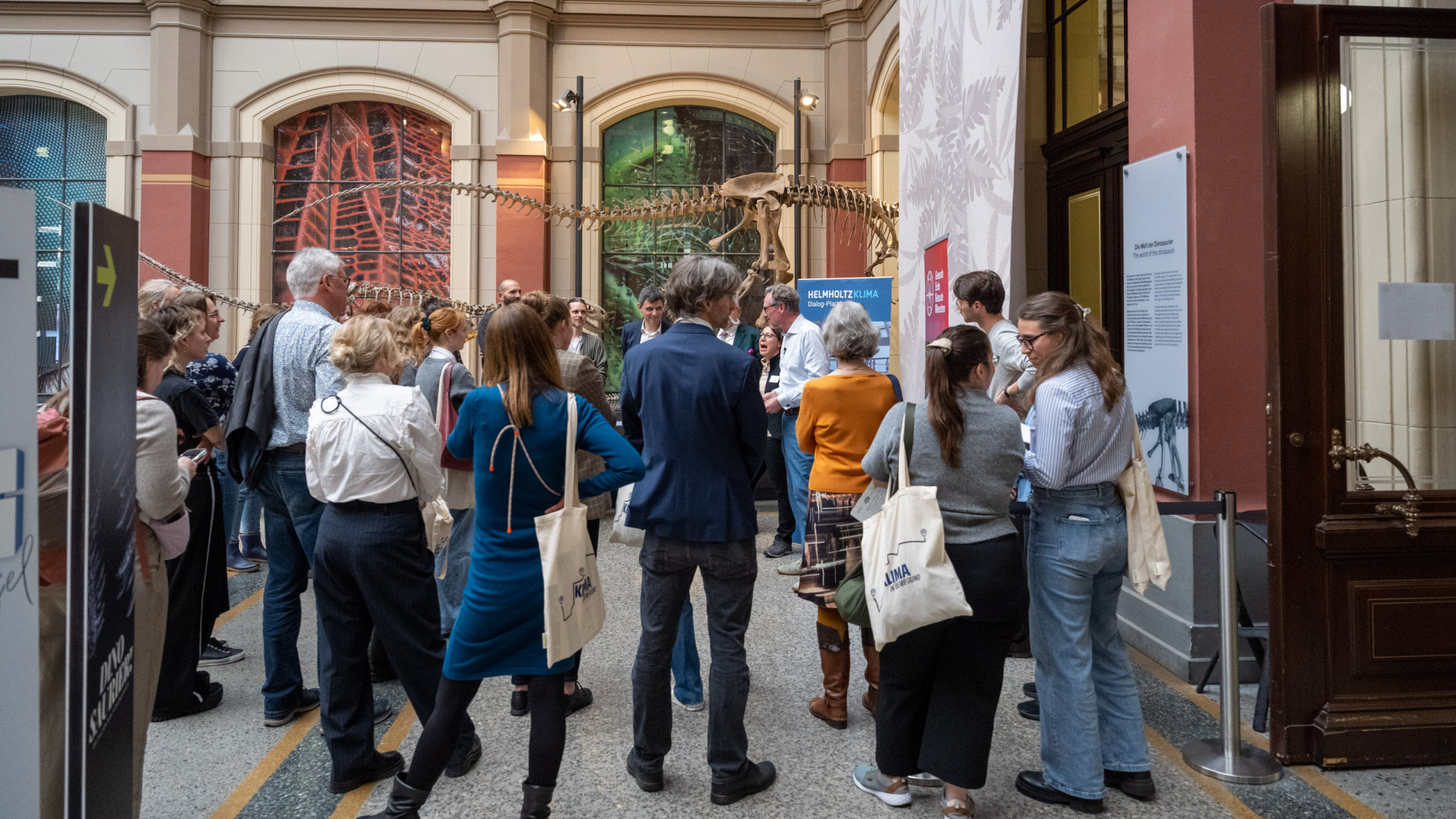 Eine Gruppe von Menschen vor einem Saurierskelett im Museum für Naturkunde 