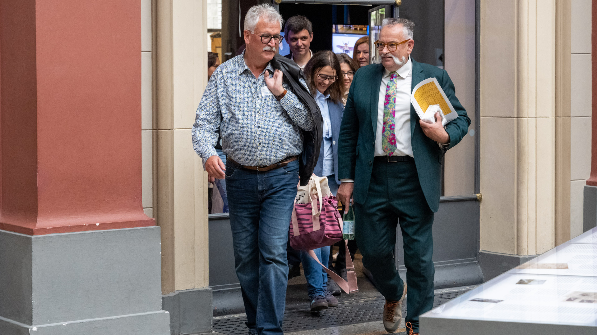 Eine Gruppe verlässt ein Gebäude, vorn in der Reihe gehen Johannes Vogel und Josef Settele.