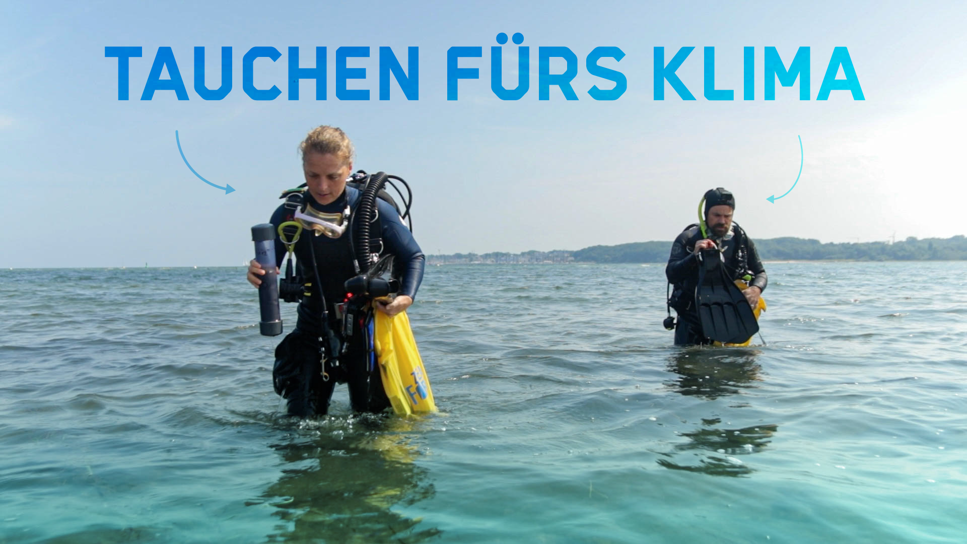 Zwei Taucher stehen im kniehohen Wasser der Ostsee